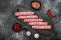 A natural raw sausage, on black dark stone table background, top view flat lay Royalty Free Stock Photo
