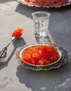 Natural red caviar on silver plate on gray surface Royalty Free Stock Photo