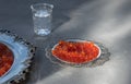 Silver plates with red caviar on gray surface Royalty Free Stock Photo