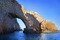 Natural rock arch extending out in the blue sea on the Ionian coast of Greece