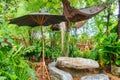 Natural rock table, seat and parasol in tropical garden on backyard