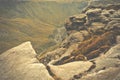 A natural rocks formation with a view of the green fields of the Royalty Free Stock Photo