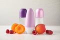 Natural roll-on deodorants with apricots and raspberries on white table Royalty Free Stock Photo