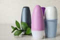 Natural roll-on deodorants and green plant on grey table Royalty Free Stock Photo