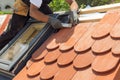 Natural roof tile instaalation. Roofer builder worker use ruller to measure the distance between the tiles. Roof with mansard wi