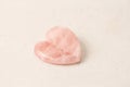 Natural rose quartz heart stone on light background. Natural stones, crystals for magic, lithotherapy, geology, minerals, stone