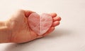 Natural rose quartz heart stone is on a woman`s hand, in the palm of her hand, on a light background. Natural stones, crystals fo Royalty Free Stock Photo