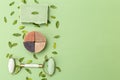 Natural round soap and face roller on green background with eucalyptus leaves. Undertone. Copy space