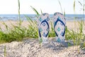 Colorful beach slippers on natural sand, summer background Royalty Free Stock Photo