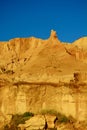 Natural sandstone formations: formed from cemented sand grains, yellow-orange in colour, forming rough cliffs against bright blue Royalty Free Stock Photo