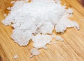 Natural sea salt on wooden background. Anthos sea salt. Flakes of natural sea salt. Royalty Free Stock Photo