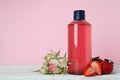Natural shower gel and ingredients against pink background