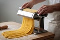 Pasta maker rolls fresh egg dough through manual machine with smooth repetition Royalty Free Stock Photo