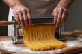 Pasta maker rolls fresh egg dough through manual machine with smooth repetition Royalty Free Stock Photo