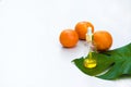 Natural skin care beauty products. Aromatic oils in glass bottles, vitamin C serum on green leav on white background.