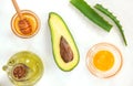 Natural skin care products, top view ingredients avocado, aloe, egg and honey on white background