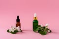 Natural skincare bottle container with green leaf , flowers ingredients on pink background. Home made remedy and beauty product Royalty Free Stock Photo