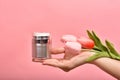 Natural skincare bottle, Hand showing pump cosmetic containers packaging with tulip flower essence extract