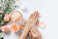 Natural skincare concept. woman apply white cream on her hands on white background with jar of cosmetic cream, salt spa scrub