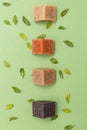 Natural soap triangular pieces on green background. Vertical format. Organic