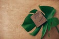 Natural soap on wooden background with green monstera leaf. Plastic free beauty essentials. Zero waste concept, flat lay with copy Royalty Free Stock Photo