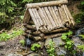 Natural source of spring water in forest flowing from a wooden well Royalty Free Stock Photo