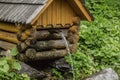 Natural source of spring water in forest flowing from a wooden well Royalty Free Stock Photo