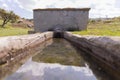 Natural spring water flowing from the pipe and the water trough Royalty Free Stock Photo