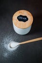 Natural stevia sweetener in a white bowl with a wooden spoon, grey marble table Royalty Free Stock Photo