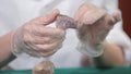 Natural stone amethyst or another mineral, stone. Wild amethyst in female hands in white gloves. Rock stone in hands Royalty Free Stock Photo