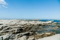 Natural stone beach over blue seacoast skyline Royalty Free Stock Photo