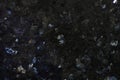 Natural stone black granite with shiny blue mica splashes, labradorite Royalty Free Stock Photo