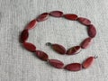Natural stone, irregularly shaped red jasper beads on a burlap background Royalty Free Stock Photo
