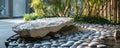 A natural stone podium with an irregular shape, surrounded by small, round river rocks. The organic Royalty Free Stock Photo