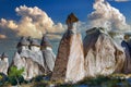 Natural stone statues against a picturesque cloudy sky in the evening in Cappadocia