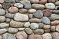 Natural stone wall of round stone, front and back background blurred with bokeh effect Royalty Free Stock Photo