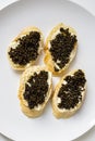 Natural sturgeon black caviar sandwiches on a white plate, luxury seafood delicacy Royalty Free Stock Photo