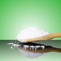 Natural sugar powder in wooden spoon in green background Royalty Free Stock Photo