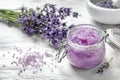 Natural sugar scrub and lavender flowers on white wooden table. Cosmetic product