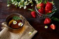 Natural summer breakfast. Organic chamomile tea, antioxidant. Fresh strawberries, chamomile flowers and mint on wooden