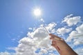 Natural sunburst from sun-heat and the heighest of mercury column thermometer in hand with blue sky and clouds background. Royalty Free Stock Photo