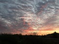 Natural Sunset Sunrise Over village. Bright Dramatic Sky And Dark Ground. Countryside Landscape Under Scenic Colorful Sky At