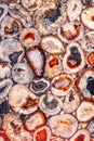 Natural surface of a crystal of red, beige and brown agate in a cross-sectional polished section