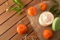 Natural tangerine cosmetic cream on table with fruit and leaves