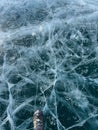 The natural texture of winter ice with white bubbles and cracks on a frozen lake. Abstract background of ice and cracks on the Royalty Free Stock Photo