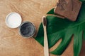 Natural toothpaste activated charcoal and bamboo toothbrush on wooden background with green monstera leaf. Plastic free beauty Royalty Free Stock Photo