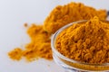 Natural turmeric powder on white acrylic background