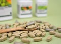 Natural vitamins and supplements in a wooden spoon on a green background. Healthy lifestyle concept. Close-up. Selective focus Royalty Free Stock Photo