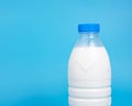 Natural white milk in plastic bottle on blue background with copyspace selective focus Royalty Free Stock Photo