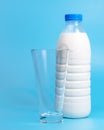 Natural white milk in plastic bottle on blue background with copyspace selective focus Royalty Free Stock Photo